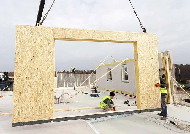 Hombres construyendo casa prefabricada